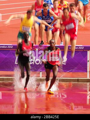 Les concurrents vont au-dessus du saut d'eau pendant la chaleur 2 du Round 1 de la Steeplechase de 3000 m pour Homme Banque D'Images