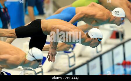 Le Michael Phelps (centre) des États-Unis plonge dans la piscine au début de la chaleur papillon des hommes de 200 m au centre aquatique du parc olympique de Londres. Banque D'Images