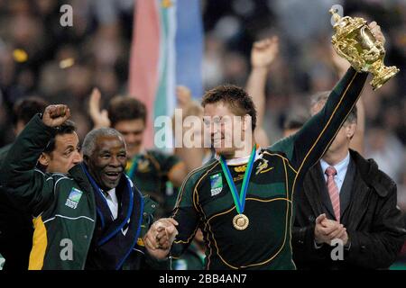 John Smit (Afrique du Sud, capitaine, à droite) tient la coupe en altitude alors qu'il regarde le président sud-africain Thabo Mvuyelwa Mbeki frapper l'air en célébration. Banque D'Images