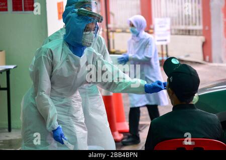 Kuala Lumpur, Malaisie. 30 mars 2020. Un membre du personnel médical prend l'échantillon d'un homme dans une zone de test COVID-19 d'un hôpital de Damansara près de Kuala Lumpur, Malaisie, le 30 mars 2020. Au total, 37 personnes sont mortes du COVID-19 en Malaisie lundi avec 156 nouveaux cas confirmés, portant le total à 2 626, a déclaré le Ministère de la Santé. Crédit: Chong Voon Chung/Xinhua/Alay Live News Banque D'Images