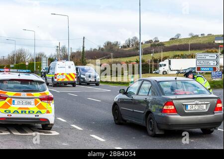 Clonakilty, West Cork, Irlande. 30 mars 2020. Dans le cadre de l'ordonnance obligatoire « Stay at Home » imposée par le gouvernement irlandais vendredi dernier, le Gardai a été chargé de s'assurer que les gens se conforment pour aider à stopper la propagation de Covid-19. Un point de contrôle de Garda a été en place sur la route Clonakilty à Bandon cet après-midi qui se composait de 3 Gardai réguliers et 2 Gardai armés. Crédit : AG News/Alay Live News Banque D'Images