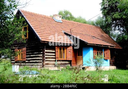 Un ancien chalet rural en bois dans les Carpates avec un porche et volets dans le désert Banque D'Images