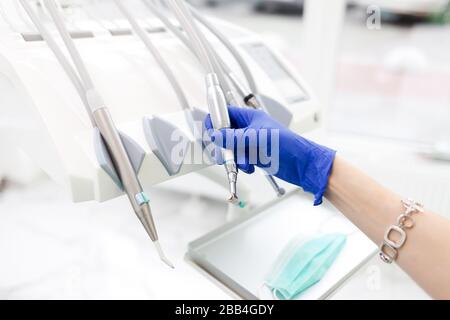 La main du dentiste prend l'un des nombreux exercices. Concept d'équipement dentaire Banque D'Images