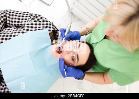 Jeune belle femme traite les dents à l'armoire de dentiste. Traitement dentaire Banque D'Images