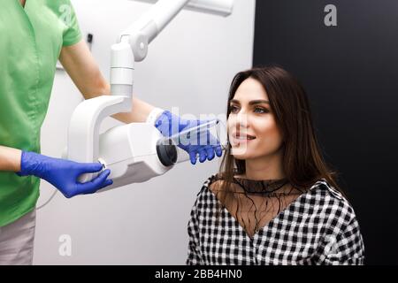 Le dentiste produit des rayons X de la cavité dentaire pour le patient en clinique Banque D'Images