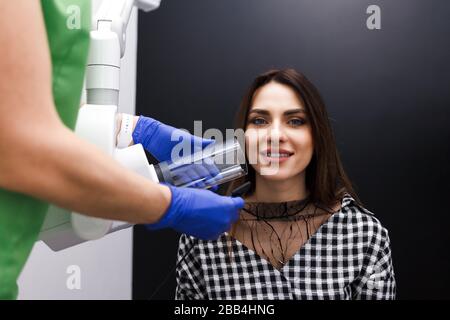 Le dentiste produit des rayons X de la cavité dentaire pour le patient en clinique Banque D'Images