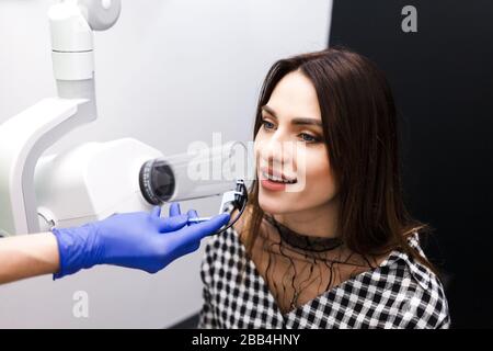 Le dentiste produit des rayons X de la cavité dentaire pour le patient en clinique Banque D'Images