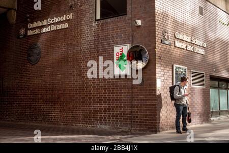 La Guildhall School of Music and Drama, Londres. Un étudiant se tenant à l'extérieur de l'entrée principale du conservatoire des arts de la scène. Banque D'Images