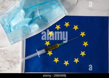 coût de la dégradation du coronavirus en europe masque médical et vaccin sur le drapeau européen Banque D'Images