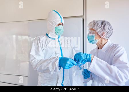 Les médecins examinent l'échantillon de salive dans l'épidémie de coronavirus en laboratoire pour le SRAS-COV-2 Banque D'Images