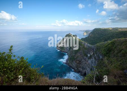 Côte sud de Nusa Penida, avec falaises de jungle et chutes d'eau versant dans la mer, au lever du soleil à Bali, Indonésie Banque D'Images