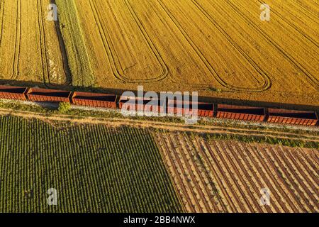 Le transport ferroviaire de marchandises, vue aérienne du train passant sur le chemin de fer par les champs cultivés dans la campagne Banque D'Images