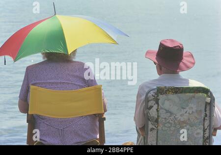 Deux retraités assis dans des chaises pliantes le long du front de mer à Southend-on-Sea. Southend, Essex. Angleterre. ROYAUME-UNI Banque D'Images