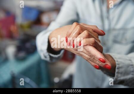 Femme utilisant une lotion hydratante pour la désinfection Banque D'Images