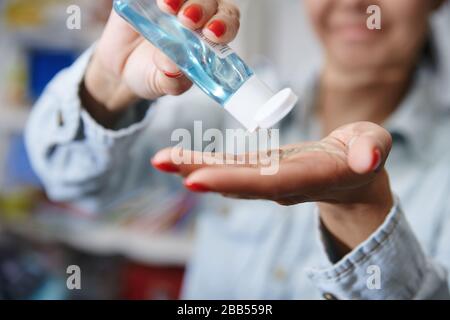 Femme utilisant une lotion hydratante pour la désinfection Banque D'Images