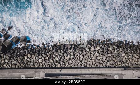 Vue aérienne de blocs de cube de ciment protégeant la rive des vagues puerto de las nieves sur l'île des Canaries Gran Canaria, Espagne. Banque D'Images