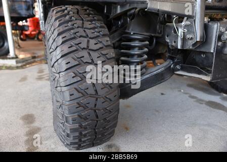 Gros plan nouveau pneu militaire de jeep et suspension de voiture d'une jeep vintage à l'extérieur Banque D'Images