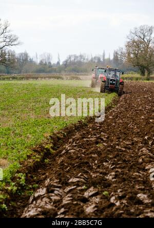 Deux tracteurs labourent un champ dans le Warwickshire, au Royaume-Uni Banque D'Images