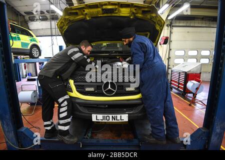 Sous embargo jusqu'à 0001 mardi 31 mars un mécanicien NHS et un mécanicien AA vérifient le moteur d'une ambulance, à l'atelier du Service ambulancier de Londres à Fulham, Londres. Banque D'Images