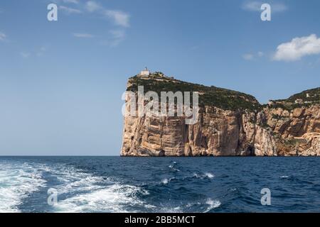 Eau bleu foncé calme de la mer Méditerranée, péninsule environnante Capo Caccia. Petits nuages sur un ciel bleu. Sardaigne, Italie. Banque D'Images