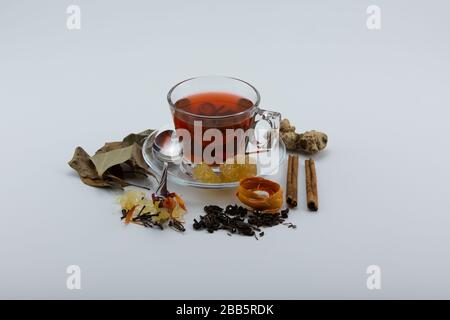 Gros plan d'une tasse de tisanes et de diverses herbes sur fond blanc Banque D'Images