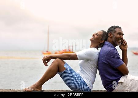 Happy mid-adult couple au bord d'un front de mer. Banque D'Images