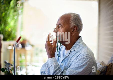 Bien homme âgé utilise un masque à oxygène. Banque D'Images