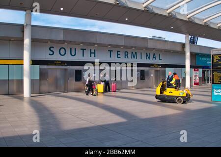 Un petit groupe de voyageurs dans un terminal sud de l'aéroport de Gatwick largement déserté, pris pendant l'urgence mondiale de santé du virus corona Banque D'Images