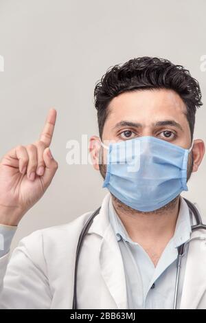 Médecin asiatique dirigé vers le haut. Homme debout et regardant la caméra. Concept de produit médical. Vue de face isolée sur fond blanc. Banque D'Images