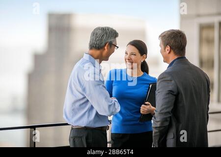Des collègues de bureau en conversation sur un balcon. Banque D'Images