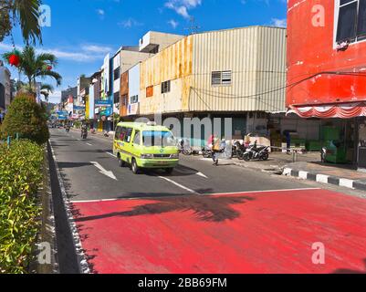 dh trafic de la ville indonésienne AMBON MALUKU INDONESIA Street bâtiments minibus van cyclist Road Banque D'Images