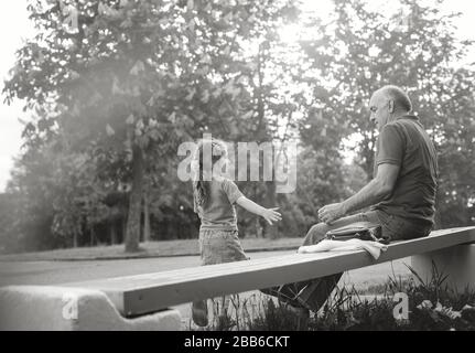 Portrait noir et blanc de grand-père heureux et de petite-fille jouant à l'extérieur Banque D'Images