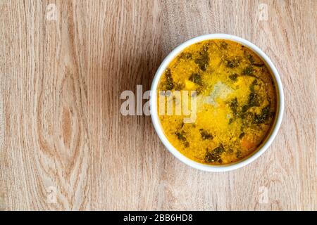 Soupe de pommes de terre, épinards, carottes, viande. Bol de soupe sur fond de bois. Espace de copie Banque D'Images