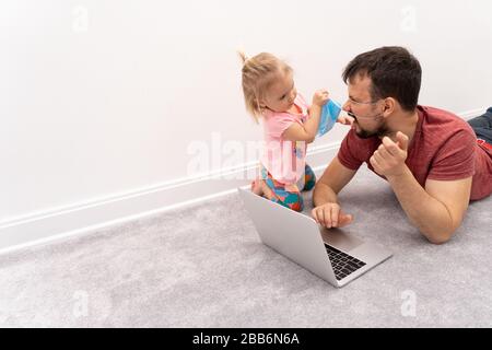 L'homme dans le masque de protection faciale et sa fille essaie de le mettre de son visage Banque D'Images