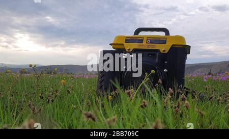 Gros plan sur l'herbe du générateur d'électricité portable mobile diesel à gaz. Le générateur portable à essence alimenté en carburant fournit du courant électrique. Banque D'Images