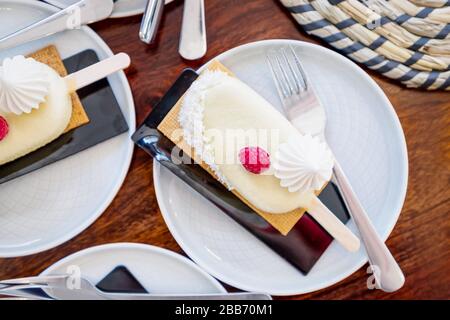 Dessert de mini-mousse recouvert de chocolat blanc. Gâteau en forme de crème glacée sur le bâton Banque D'Images