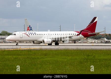 A TACA International Airlines Embraer 190 prêt à quitter l'aéroport international de Miami. Banque D'Images