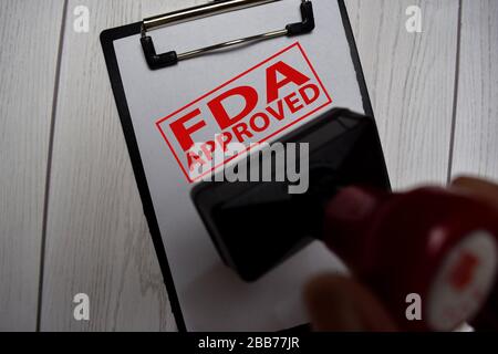 Gros plan poignée rouge Stamper caoutchouc et texte approuvé FDA isolé sur fond blanc. Mise au point sélective sur les produits approuvés par la FDA Banque D'Images