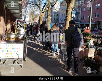 File d'attente des personnes ou de la ligne d'attente à l'entrée du supermarché , en partie avec masque facial et distance de sécurité , nouvelles mesures de sécurité - virus corona / covid-19 Banque D'Images