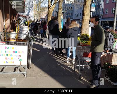 File d'attente des personnes ou de la ligne d'attente à l'entrée du supermarché , en partie avec masque facial et distance de sécurité , nouvelles mesures de sécurité - virus corona / covid-19 Banque D'Images