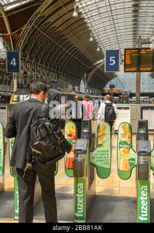 LONDRES, ANGLETERRE - JUILLET 2018 : voyageur ferroviaire passant par une barrière automatique de billet sur le parcours de la gare de Paddington à Londres Banque D'Images