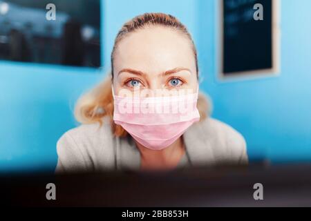 Femme portant un masque chirurgical avec covid 19 modèle dans sa main Banque D'Images