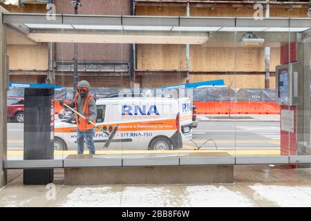 Detroit, Michigan, États-Unis. 30 mars 2020. Les travailleurs désinfectent un abri de transport en commun dans le centre-ville de Detroit. Crédit: Jim West/Alay Live News Banque D'Images