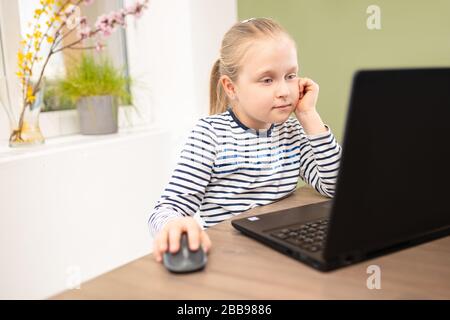 petite écolière étudiant à la maison ordinateur de quarantaine pendant la pandémie de coronavirus Banque D'Images