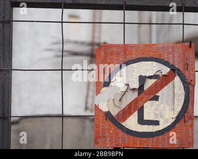 Une vieille main n'a peint aucun panneau d'entrée attaché à une clôture en fil. Banque D'Images