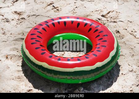 Anneau de natation gonflable multicolore sur la plage, le jour ensoleillé. Plage de la mer Noire du territoire de Krasnodar en Russie Banque D'Images