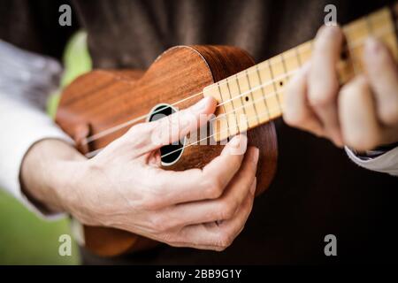 les mains du musicien jouent un ukulele acoustique Banque D'Images