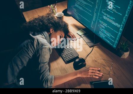 Vue en angle photo de jolie peau sombre dame d'affaires s'est endormi près de surveiller travail heures supplémentaires délai termes spécifications téléphone couché table porter décontracté Banque D'Images