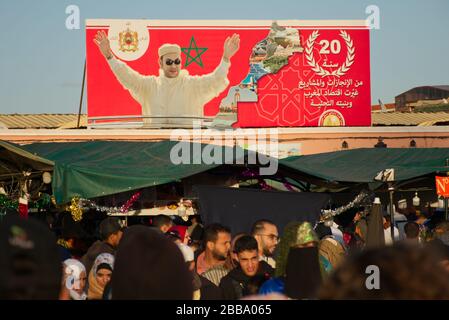 Les gens qui marchent sur le célèbre marché de Jemaa el-Fna, sous l'œil de leur président Mohammed VI Banque D'Images