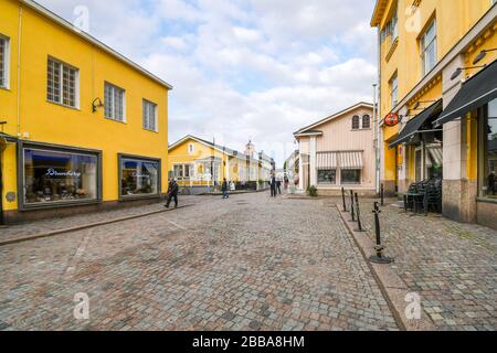 Grande rue pavée avec des bâtiments colorés à l'entrée de la ville médiévale de Porvoo Finlande. Banque D'Images